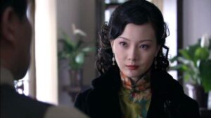 中国の女優チェン・シューが緑地の花柄旗袍と黒のコートを着ている。