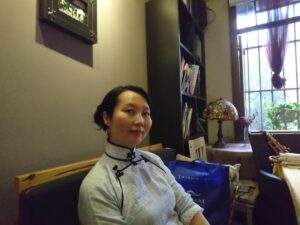 中国昆明市にある文化巷という街のカフェで、チャイナドレスを着たレイレイが座っている写真。