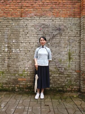 中国昆明市にある文化巷という街で、チャイナ服を着たレイレイが立っている写真。