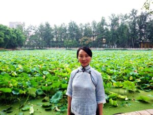 中国昆明市の翠湖で、チャイナ服を着てレイレイが笑っている写真。
