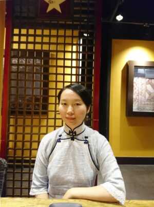中国昆明市のレストランで、チャイナ服を着たレイレイが座っている写真。