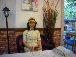 中国上海市内のカフェで、チャイナドレスを着てレイレイが座っている写真。