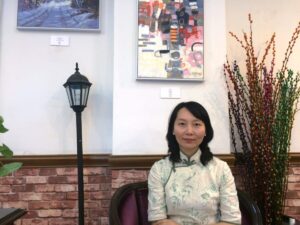 中国上海市内のカフェで、チャイナドレスを着てレイレイが座っている写真。