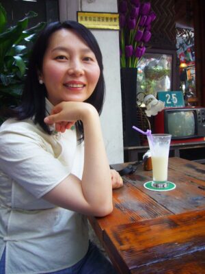 中国上海市内の田子坊という観光地のカフェで、チャイナ服を着てレイレイが笑っている写真。