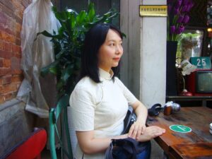 中国上海市内の田子坊という観光地のカフェで、チャイナ服を着てレイレイが座っている写真。