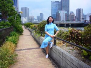 大阪市中之島の川沿いで、チャイナドレスを着たレイレイが笑っている写真。