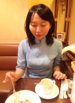 大阪市内のカフェで、チャイナドレスを着たレイレイがケーキを食べようとしている写真。