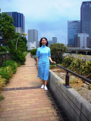 大阪市中之島の川沿いで、チャイナドレスを着たレイレイが立っている写真。